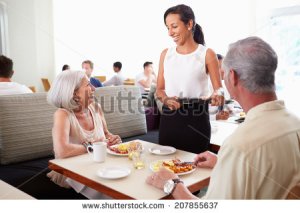 stock-photo-waitress-serving-senior-couple-breakfast-in-hotel-restaurant-207855637